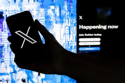 Fotografía que muestra un usuario mientras sostiene un teléfono móvil que muestra el logotipo 'X' frente a la página principal de Twitter, el 28 de julio de 2023 en Los Ángeles, California (EE.UU.). EFE/EPA/ETIENNE LAURENT