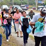 Un grupo de personas camina junto a la caravana migrante, rumbo a la frontera guatemalteca de Agua Caliente, a su paso por San Pedro Sula (Honduras). Imagen de archivo. EFE/José Valle