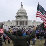 Fotografía de archivo de un seguidor de Donald Trump sosteniendo la bandera de los Estados Unidos frente al Capitolio estadounidense, en Washington (Estados Unidos). EFE/ MICHAEL REYNOLDS