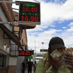 Una mujer muestra dolares frente a una casa de cambio el 31 de julio de 2023, en Ciudad Juárez (México). EFE/ Luis Torres