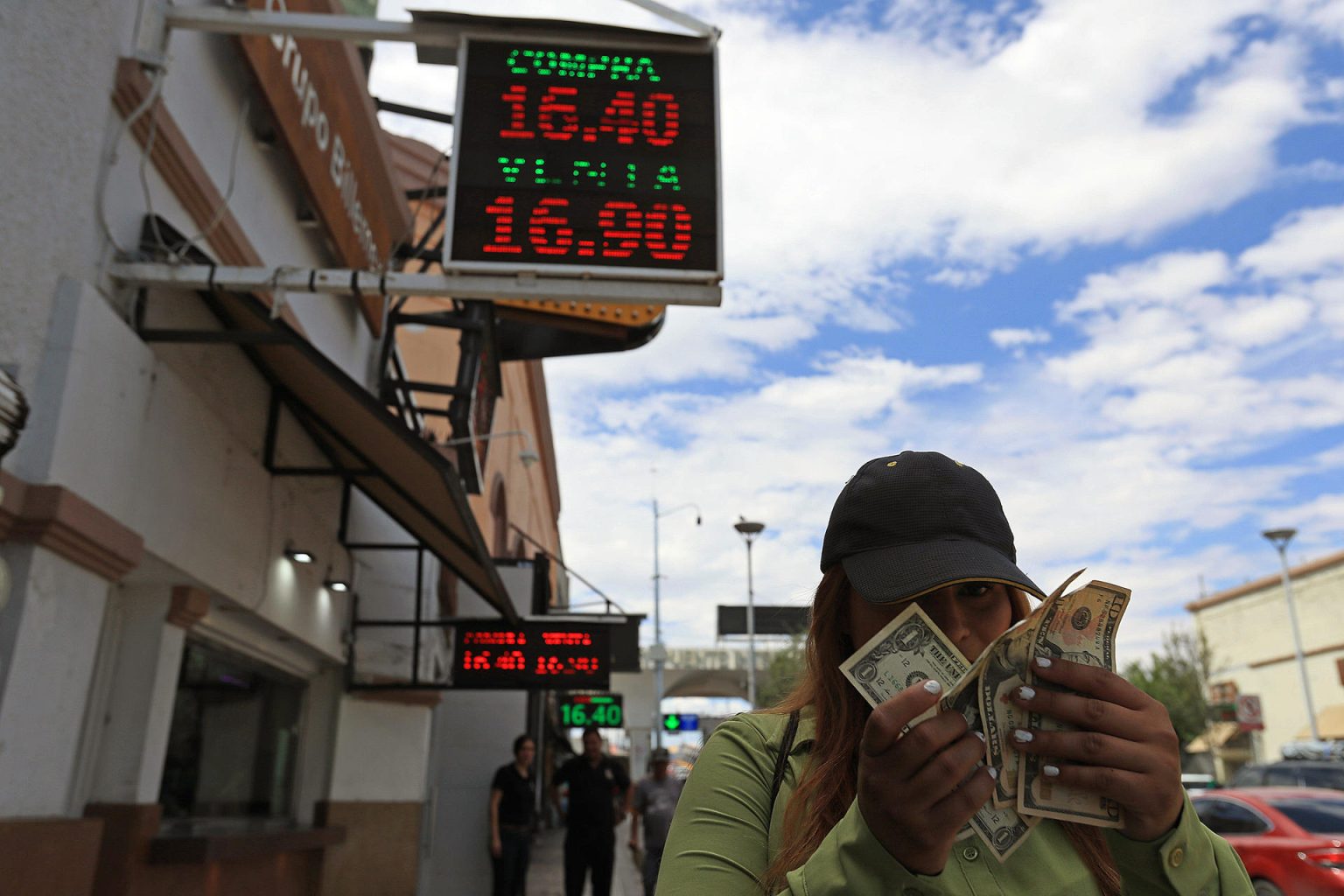 Una mujer muestra dolares frente a una casa de cambio el 31 de julio de 2023, en Ciudad Juárez (México). EFE/ Luis Torres