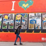 Una mujer camina frente a un mural que dice "Yo amo al Bronx" en el barrio El Bronx, en New York (Estados Unidos). EFE/Ángel Colmenares