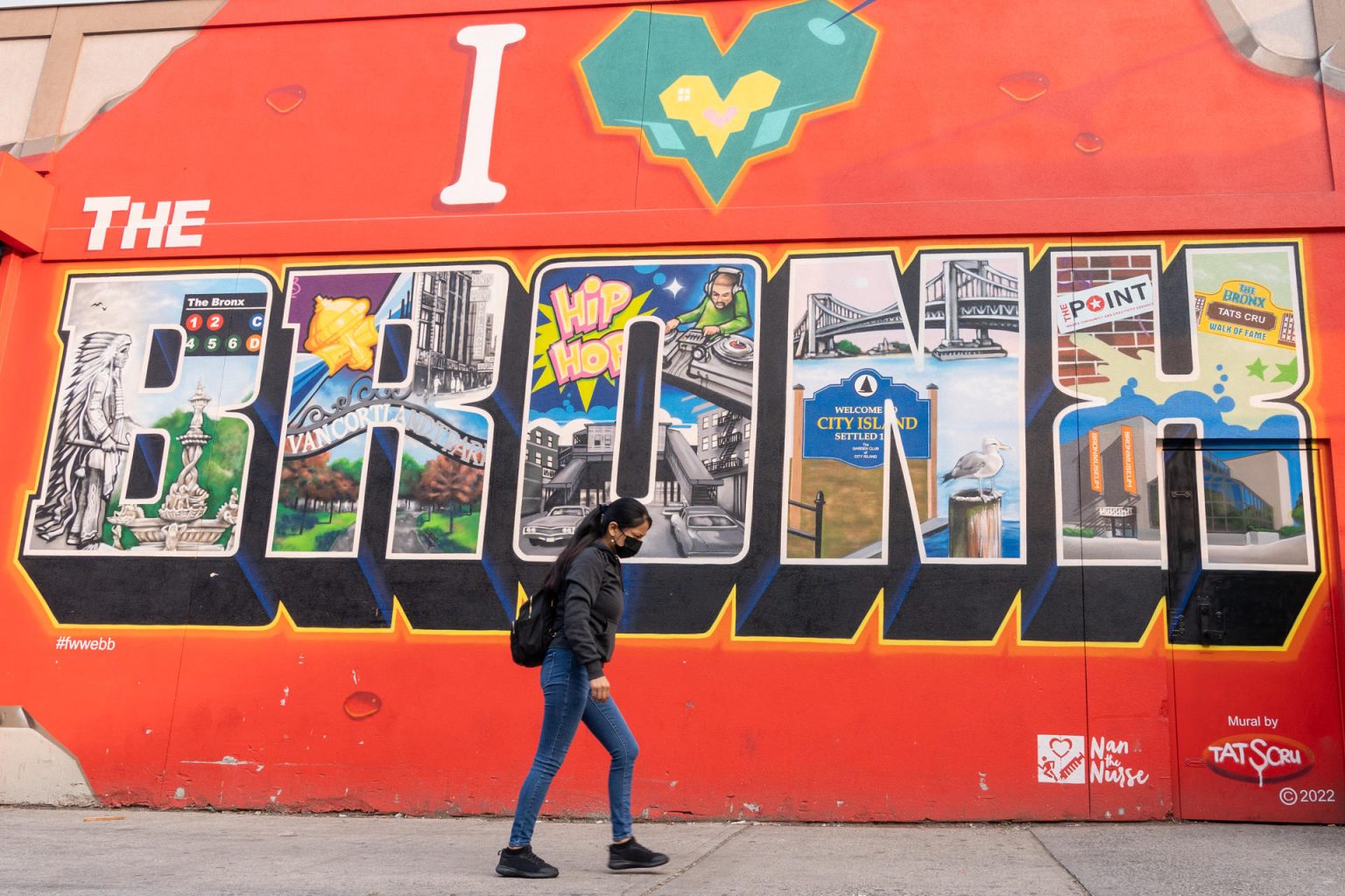 Una mujer camina frente a un mural que dice "Yo amo al Bronx" en el barrio El Bronx, en New York (Estados Unidos). EFE/Ángel Colmenares