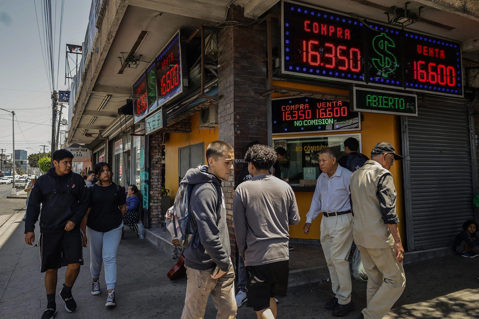 Personas caminan frente a una casa de cambio el 1 de agosto de 2023, en la ciudad de Tijuana, estado de Baja California (México). EFE/Joebeth Terríquez