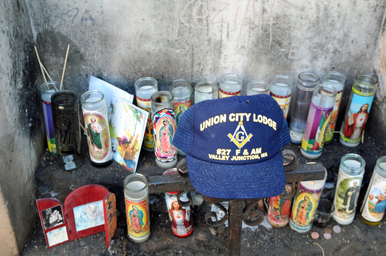 Fotografía de archivo donde se muestran veladoras de Jesucristo, la Virgen María y santos católicos depositados en una esquina de "El Tiradito", un popular santuario al aire libre al que se acogen hispanos y migrantes, que además recuerdan allí a aquellos que han fallecido a lo largo de la frontera con México, puesto en una pared de adobe de una vieja edificación en un barrio histórico de Tucson, Arizona. EFE/María León