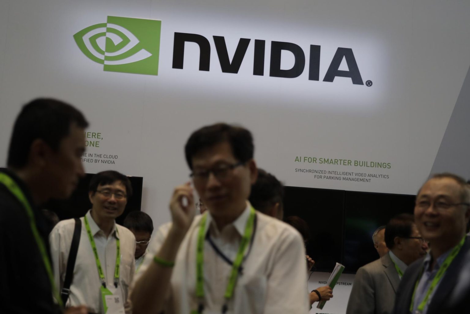 Analistas se paran junto a un logo de Nvidia. Imagen de archivo. EFE/RITCHIE B. TONGO