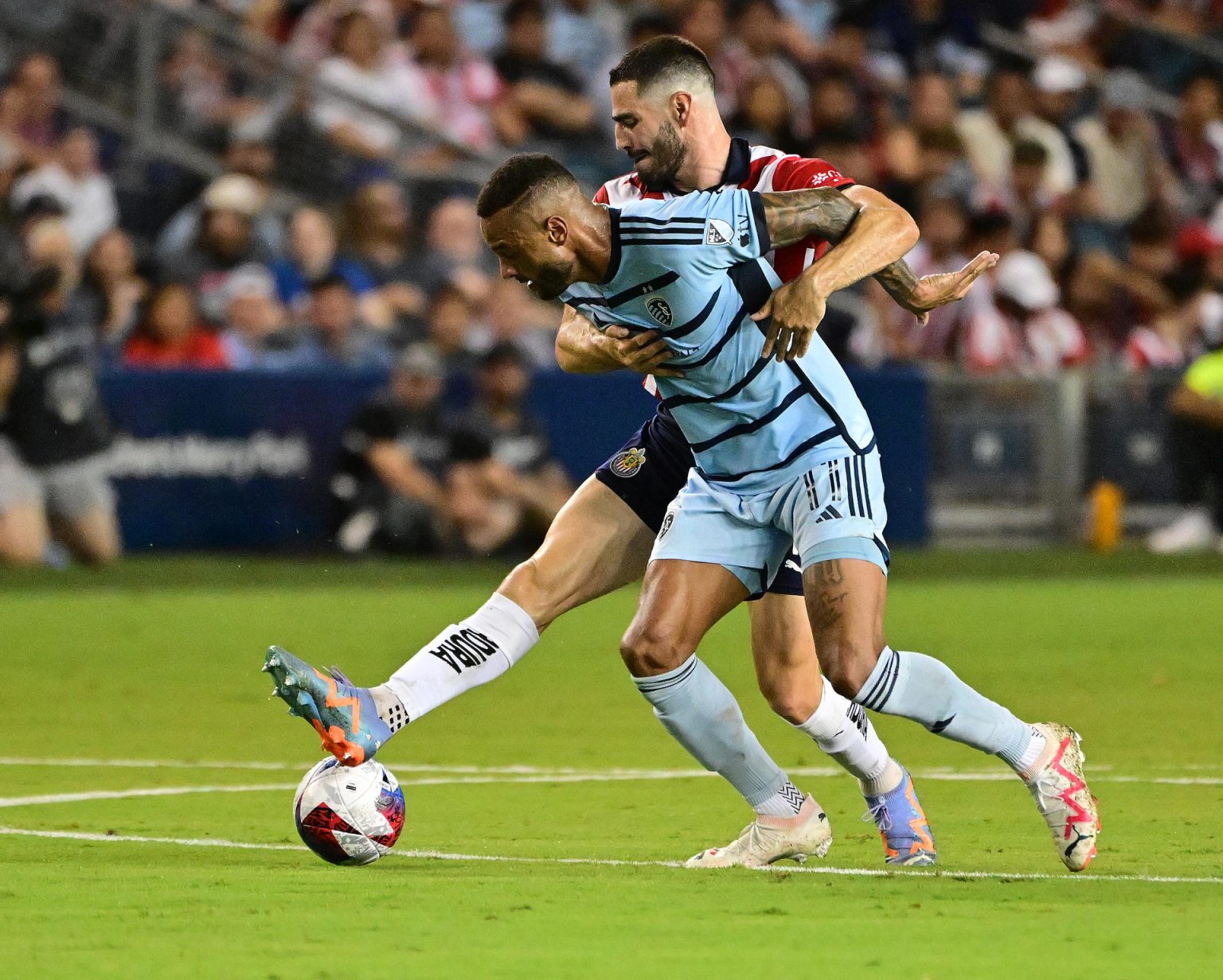 El jugador del Guadalajara José Antonio Rodríguez (atrás) disputa el balón con el mediocampista del Sporting Kansas City Gadi Kinda este 31 de julio de 2023,, en un partido de la fase de grupos de la Leagues Cup en el estadio Childrens Mercy Park en Kansas City (EE.UU.). EFE/Tim Vizer