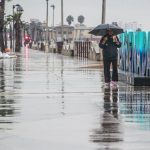 Una persona camina bajo la lluvia hoy, en el puerto de Ensenada en Baja California (México). EFE/Alejandro Zepeda