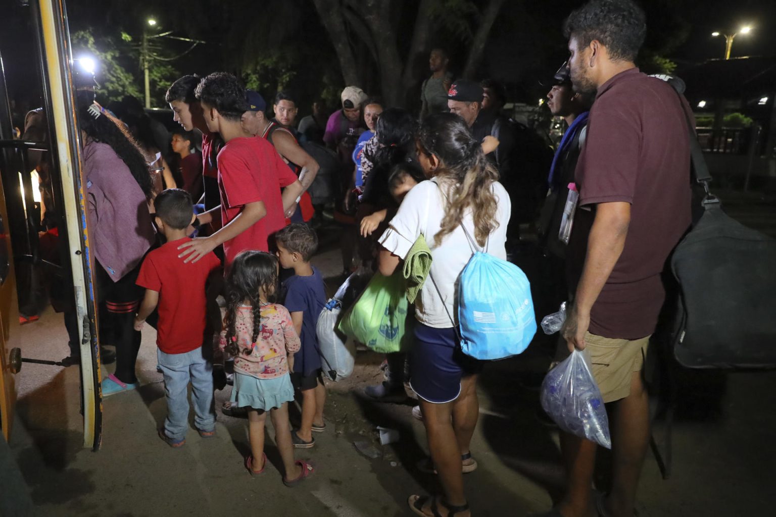 Fotografía de archivo de familias de migrantes que suben en la madrugada a un bus en la ciudad de Danlí, al oriente de Honduras. EFE/Gustavo Amador