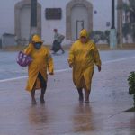 Dos personas protegidas con capas caminan en medio de un fuerte aguacero en el estado de Yucatán (México). EFE/ Cuauhtemoc Moreno