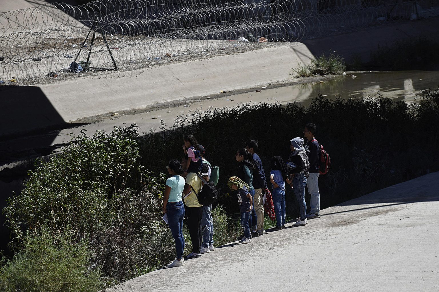 Un grupo de migrantes permanecen a un costado del río Bravo hoy, en la fronteriza Ciudad Juárez, Chihuahua (México). EFE/Luis Torres