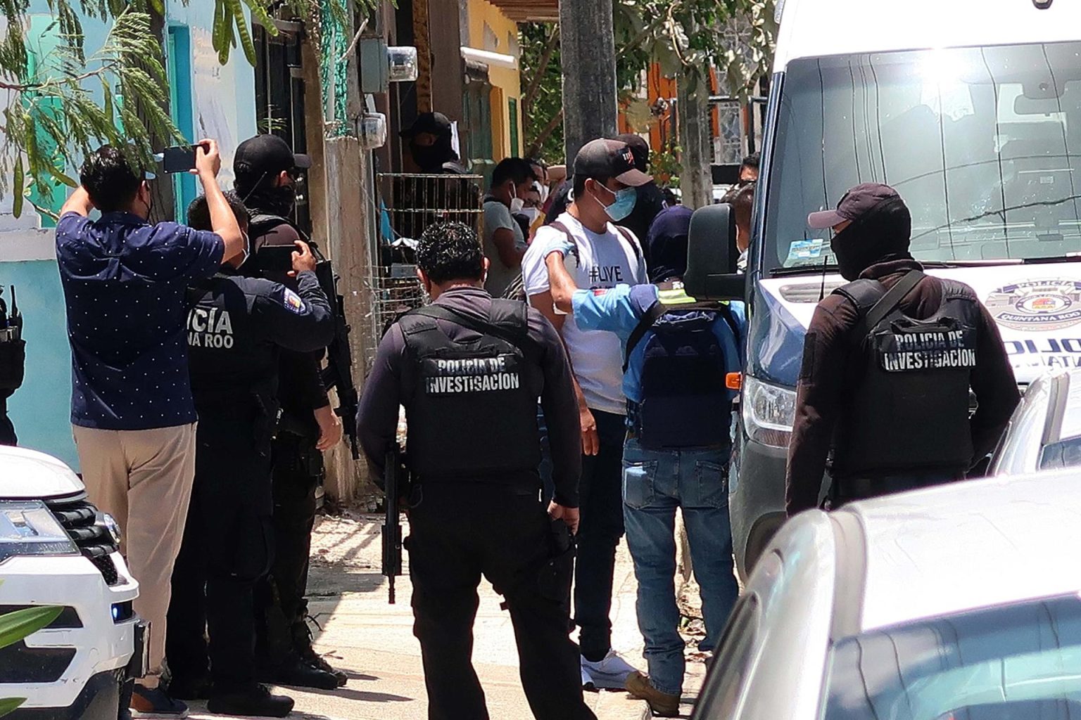 Fotografía de archivo de agentes de la Policía Ministerial de la Fiscalía General Estatal que escoltan a un grupo de migrantes asegurados en una casa de la ciudad de Cancún, estado de Quintana Roo (México). EFE/Alonso Cupul