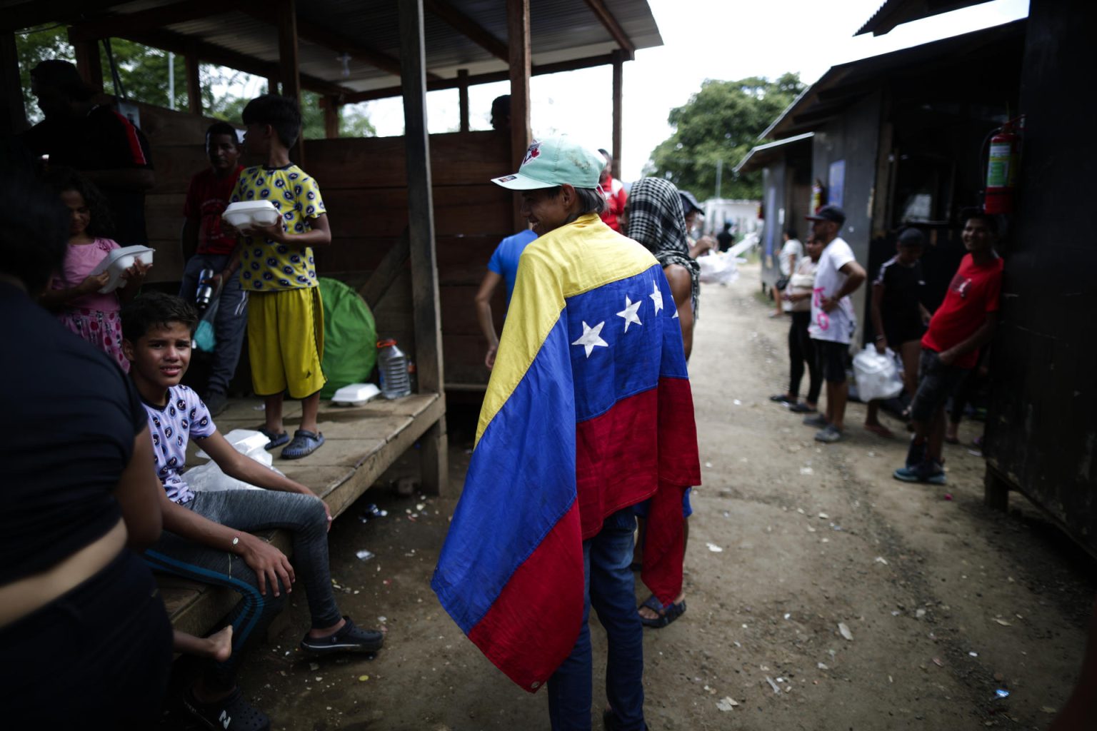 William Maldonado, un migrante venezolano de 22 años sostiene una bandera de Venezuela en una estación de recepción migratoria. EFE/ Bienvenido Velasco