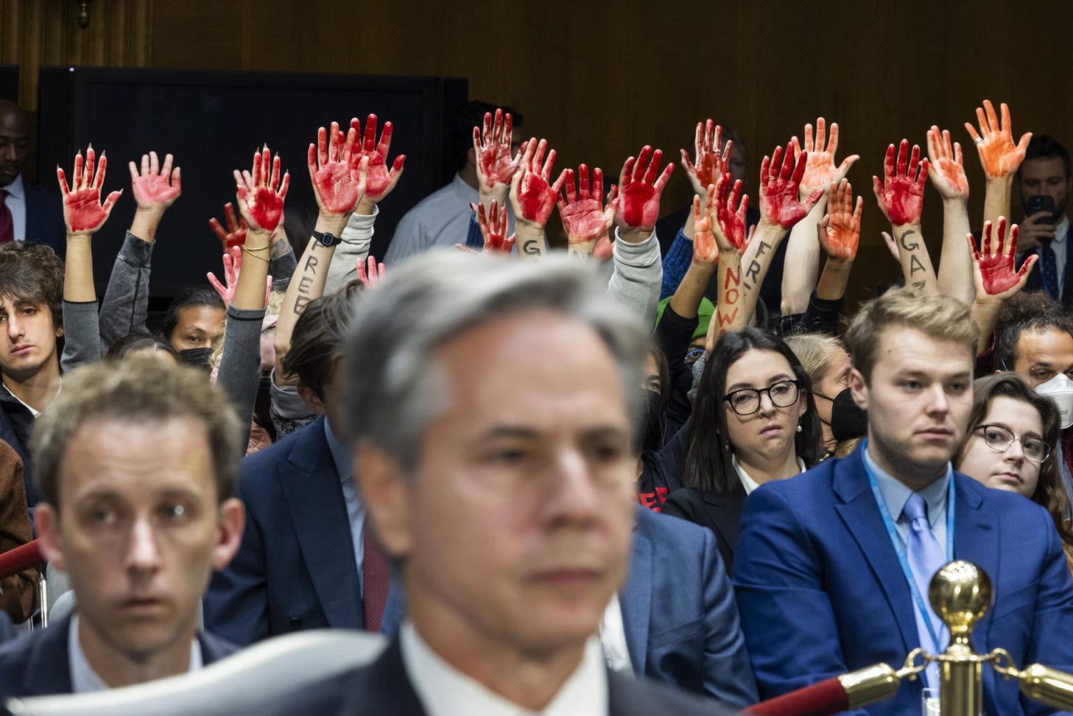 Manifestantes piden un alto el fuego para Gaza mientras alzan sus manos a la llegada del secretario de Estado estadounidense Anthony Blinken (c )a testificar acerca de temas de seguridad nacional ante un comité del Senado, este martes en Washington. EFE/JIM LO SCALZO