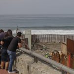 Turistas observan los trabajos del muro fronterizo hoy en las playas en Tijuana, Baja California (México). EFE/Joebeth Terríquez