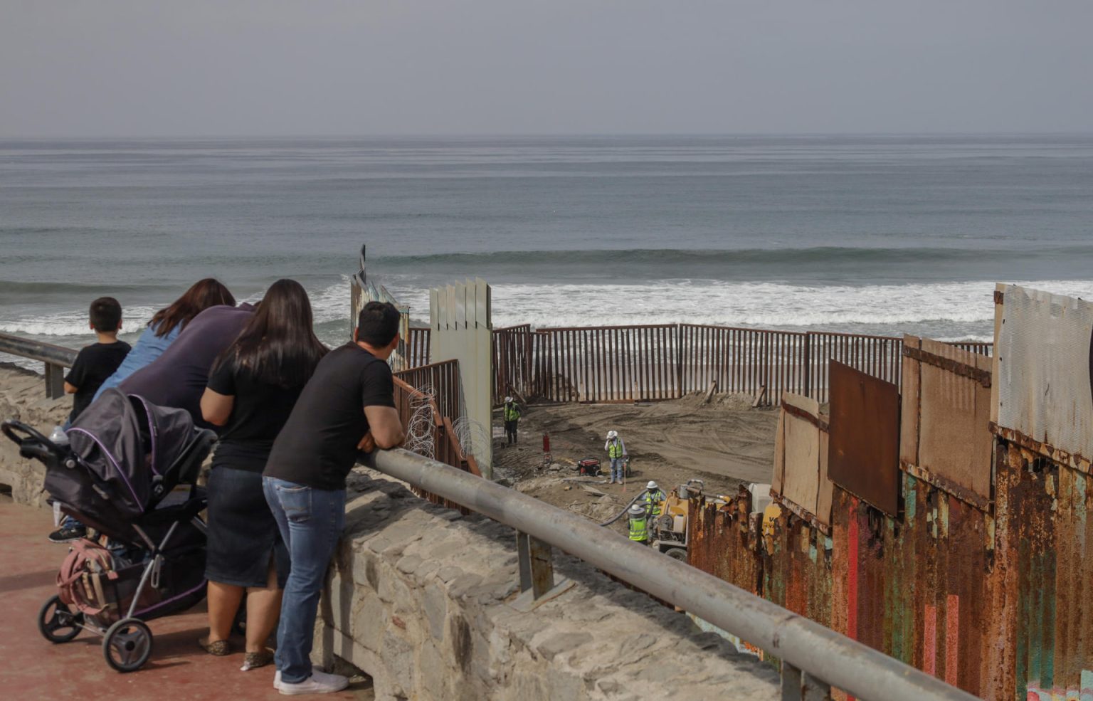 Turistas observan los trabajos del muro fronterizo hoy en las playas en Tijuana, Baja California (México). EFE/Joebeth Terríquez