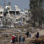 Familias palestinas caminan después de cruzar desde de norte a sur la Franja de Gaza, a lo largo de la carretera Salah Al Din este martes. EFE/MOHAMMED SABER