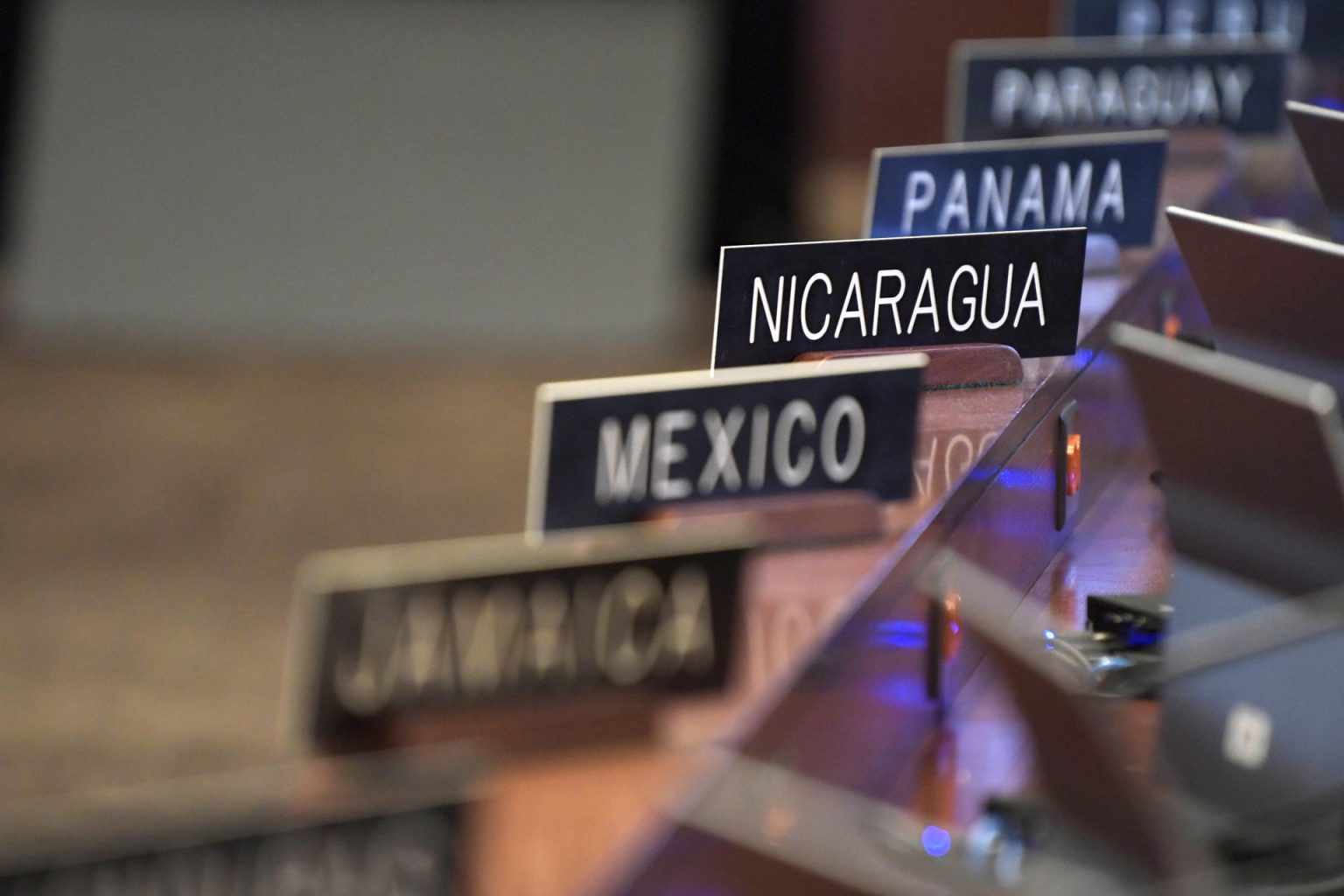 Detalle de algunas placas de los países miembros de la Organización de los Estados Americanos (OEA), desplegadas durante una sesión ordinaria del Consejo Permanente, en la sede del organismo en Washington (EE. UU). Imagen de archivo. EFE/Lenin Nolly