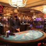 Un empleado del hotel Bellagio viste tapabocas y espera junto a una mesa de póquer con divisiones de cristal en Las Vegas, Nevada. EFE/Adriana Arévalo