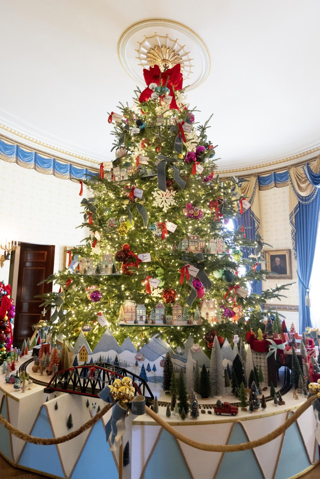 Fotografía del árbol de Navidad oficial de la Casa Blanca, un abeto fraser de 18,5 pies de altura, con una réplica de un tren de pasajeros antiguo en la base, durante una vista previa para los medios de comunicación de la exhibición navideña de la Casa Blanca de 2023, con el tema "Magia, maravilla y alegría" de las fiestas, hoy, en el Salón Azul de la Casa Blanca, en Washington (EE.UU.). EFE/ Michael Reynolds