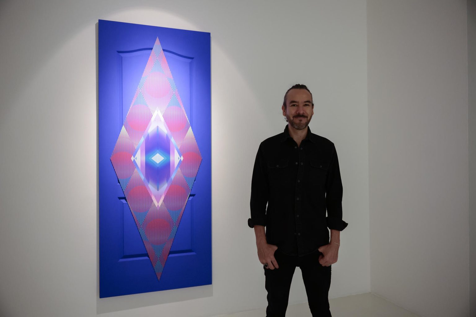 El artista mexicano Israel González posa junto a su obra "Ojo de Horus" el 14 de noviembre de 2023, en la Galería Hilario Galguera en Ciudad de México (México). EFE/José Méndez