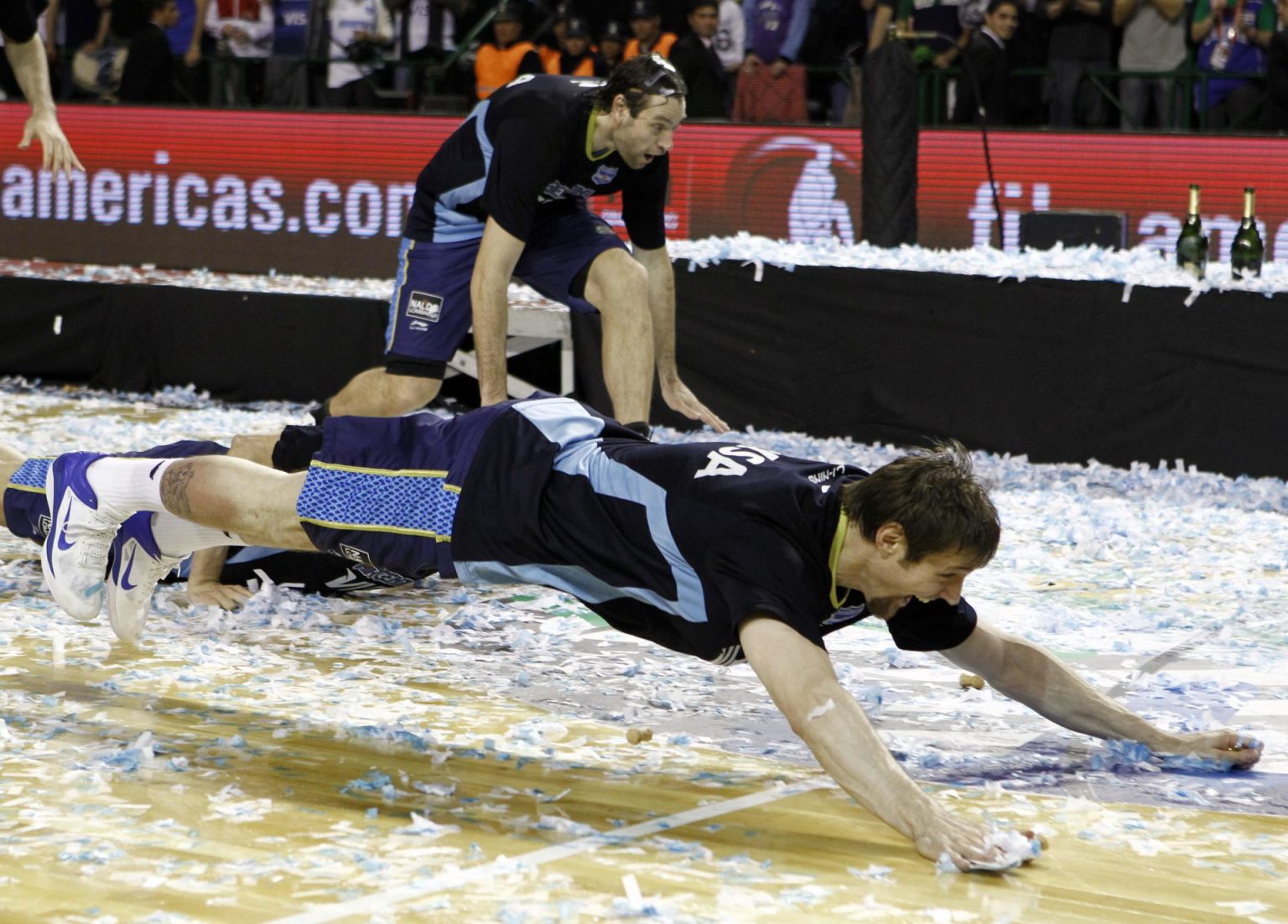 Fotografía de archivo, tomada en septiembre de 2011, en la que se registró a los argentinos Andrés Nocioni (frente) y Fabricio Oberto (fondo), al celebrar el título del torneo Preolímpico suramericano de baloncesto, en Mar del Plata (Argentina). EFE/Leo La Valle