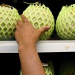 Un cliente intenta alcanzar un melón en una estantería de una verdulería donde se venden frutas y verduras. Imagen de archivo. EFE/Barbara Walton