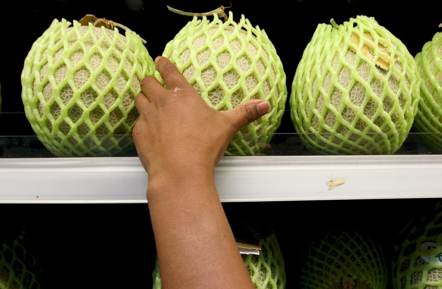 Un cliente intenta alcanzar un melón en una estantería de una verdulería donde se venden frutas y verduras. Imagen de archivo. EFE/Barbara Walton