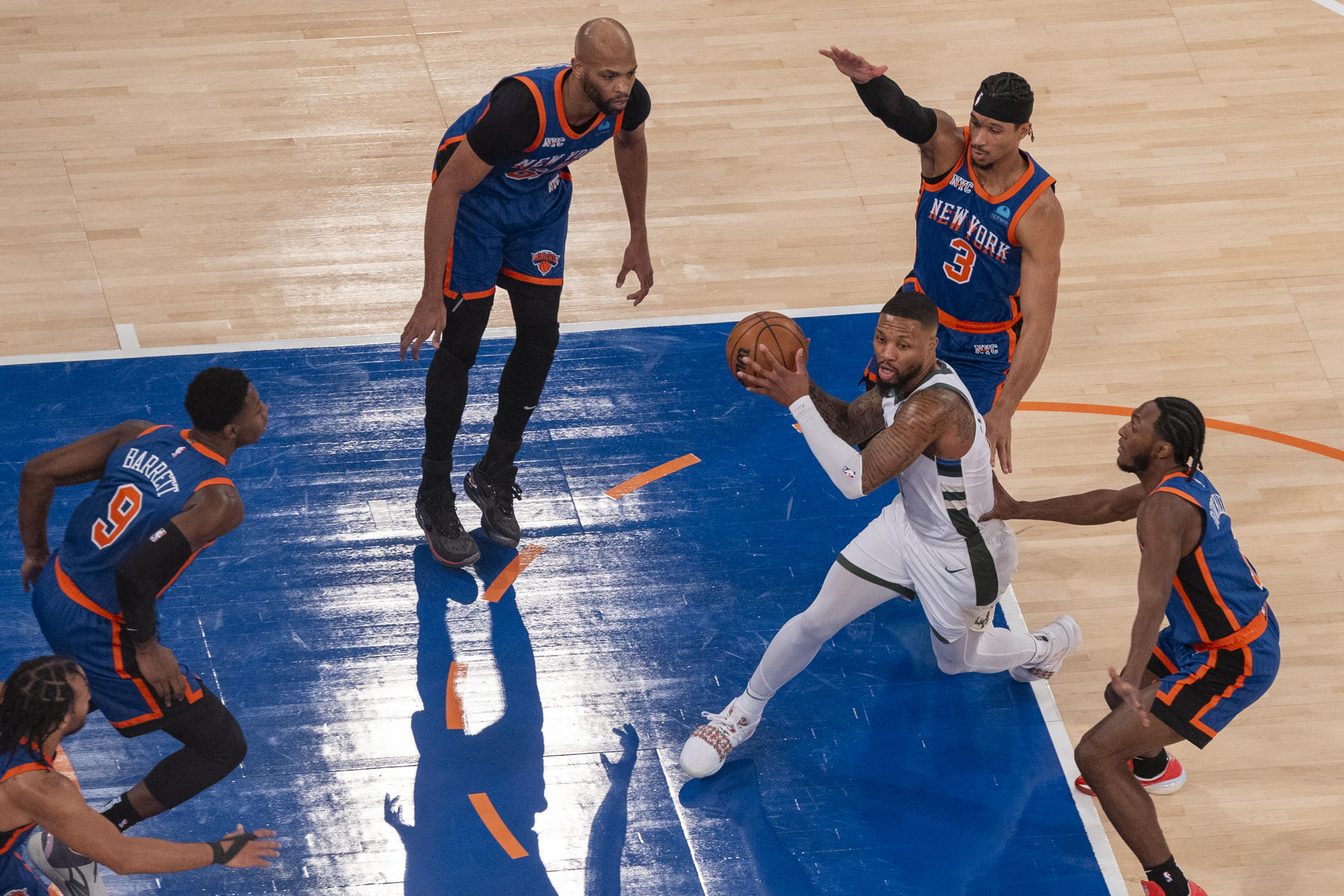 Damian Lillard (c) de los Bucks controla el balón rodeado por jugadores de los Knicks hoy, durante un partido de baloncesto de la NBA entre los New York Knicks y los Milwaukee Bucks, en el pabellón deportivo multiusos Madison Square Garden en el distrito de Manhattan, en Nueva York (EE.UU.). EFE/ Ángel Colmenares
