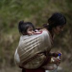 Una migrante ecuatoriana carga a su hija en la selva mientras esperan para ser trasladados en canoa desde la Quebrada León hasta a la comunidad de Bajo Chiquito, en Darién (Panamá). Imagen de archivo. EFE/ Bienvenido Velasco