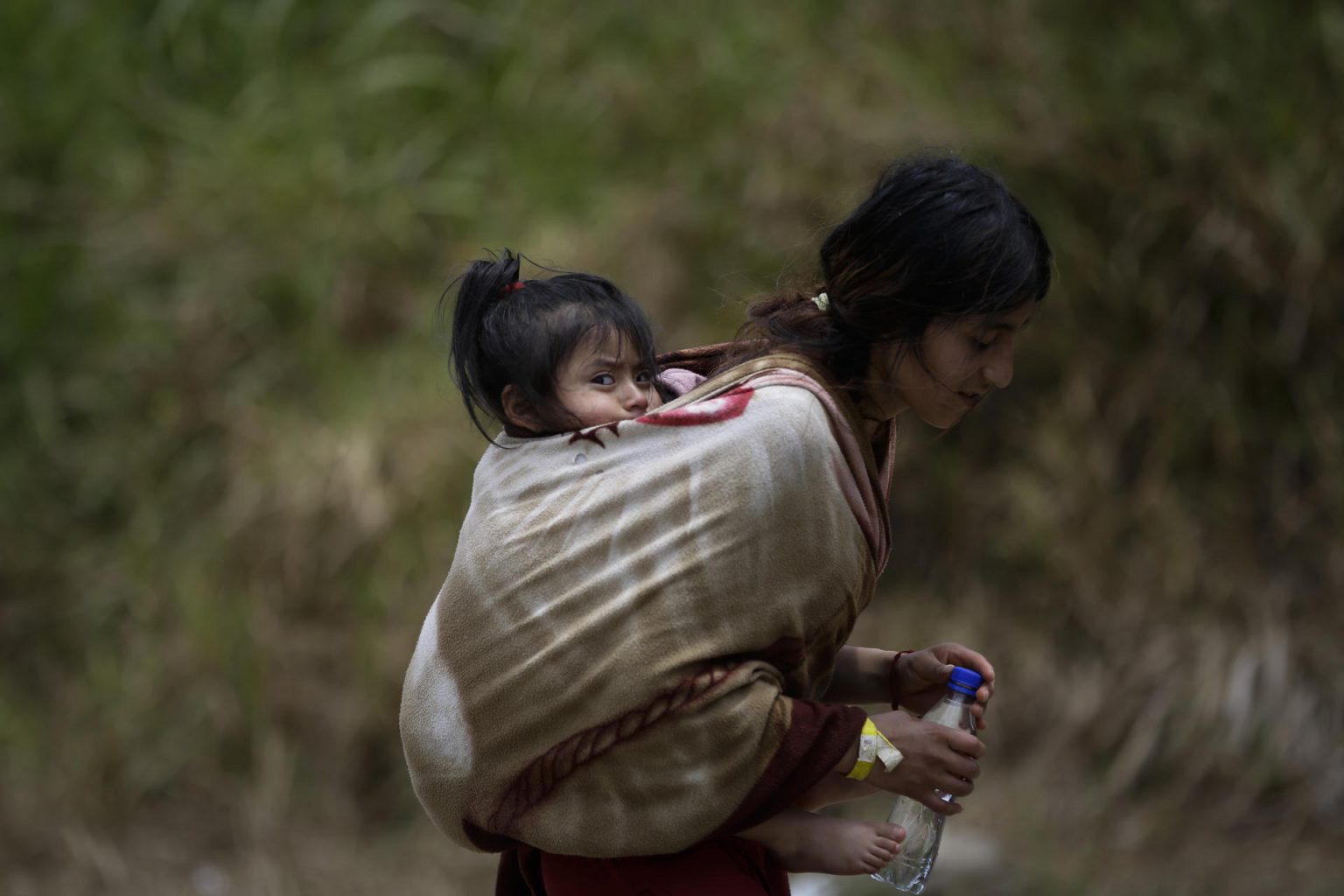 Una migrante ecuatoriana carga a su hija en la selva mientras esperan para ser trasladados en canoa desde la Quebrada León hasta a la comunidad de Bajo Chiquito, en Darién (Panamá). Imagen de archivo. EFE/ Bienvenido Velasco