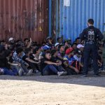 Un oficial de la policía de Aduanas de Estados Unidos (i) y un oficial de la Patrulla Fronteriza (d) reúnen a migrantes en Shelby Park, en Eagle Pass, Texas (EE.UU.), en una fotografía de archivo. EFE/Adam Davis