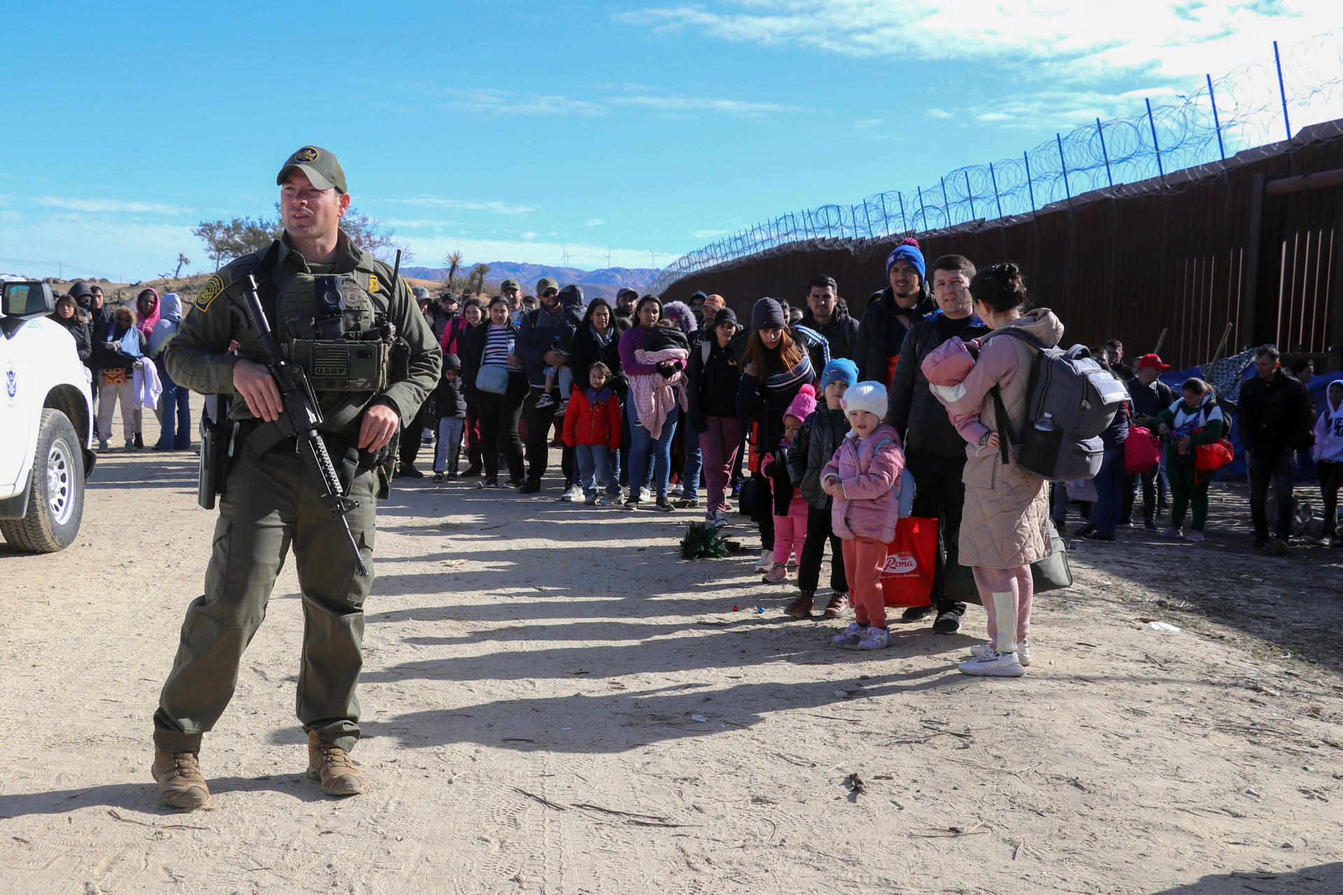 Un agente de la Patrulla Fronteriza estadounidense mantiene vigilancia junto a un grupo de migrantes, el 29 de noviembre del 2023, en el puesto fronterizo de Jacumba, a unas 75 millas (120 kilómetros) al este de San Diego, California (EEUU). EFE/Manuel Ocaño
