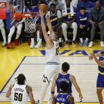 El jugador de los Denver Nuggets Nikola Jokic (c) convierte una canasta ante la mirada de sus rivales de los Golden State Warriors, en una fotografía de archivo. EFE/John G. Mabanglo