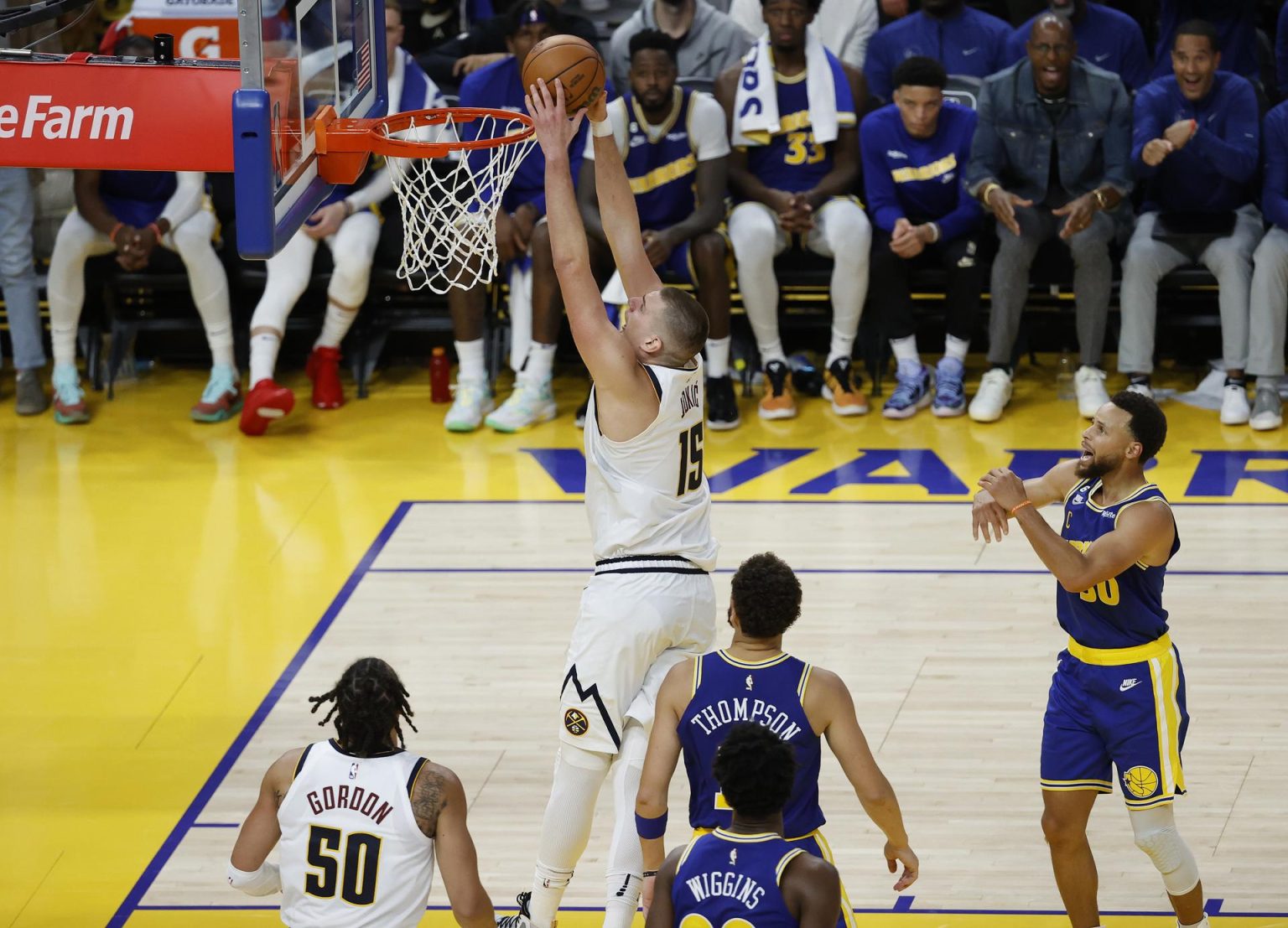 El jugador de los Denver Nuggets Nikola Jokic (c) convierte una canasta ante la mirada de sus rivales de los Golden State Warriors, en una fotografía de archivo. EFE/John G. Mabanglo