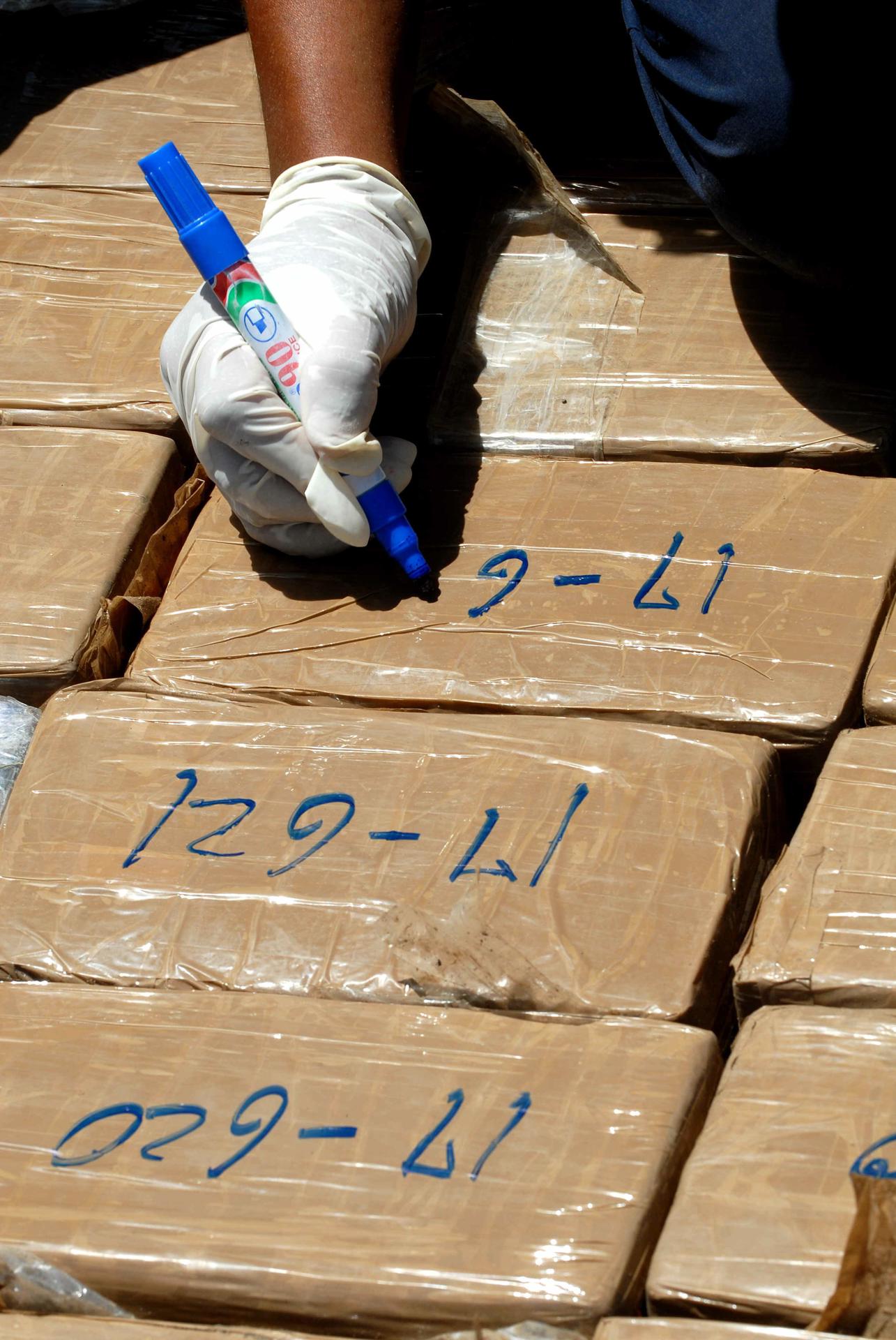 Fotografía de archivo de un miembro de la Policía que marca paquetes de cocaína de un decomiso de drogas. EFE/Mario López