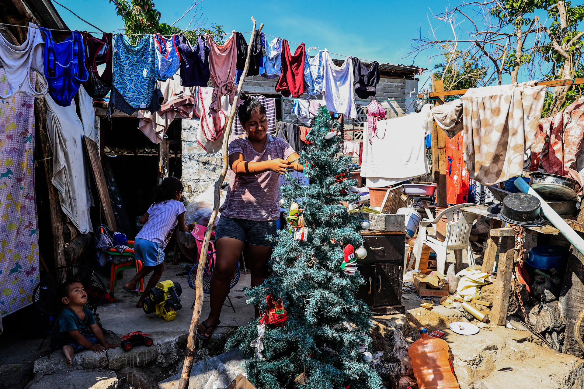 Cristal Ortiz Balderas, habitante de la colonia Cumbres de Figueroa, una de las zonas afectadas por el 'huracán Otis', pone un pino navideño, el 23 de diciembre de 2023, en Acapulco, estado de Guerrero (México). EFE/David Guzmán
