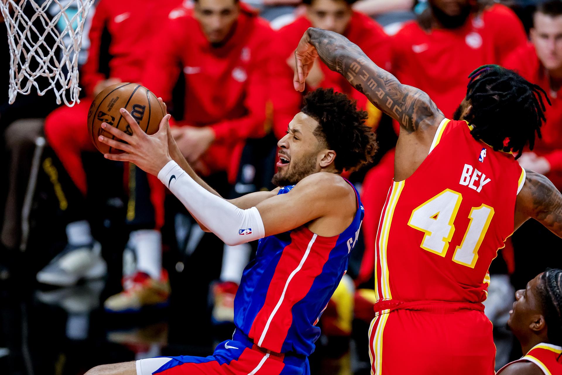 Cade Cunningham (i), de los Pistons de Detroit, fue registrado este lunes, 18 de diciembre, al atacar el aro que defiende Saddiq Bey (d), de los Hawks de Atlanta, durante un partido de la NBA, en Atlanta (Georgia, EE.UU.). EFE/Erik S. Lesser
