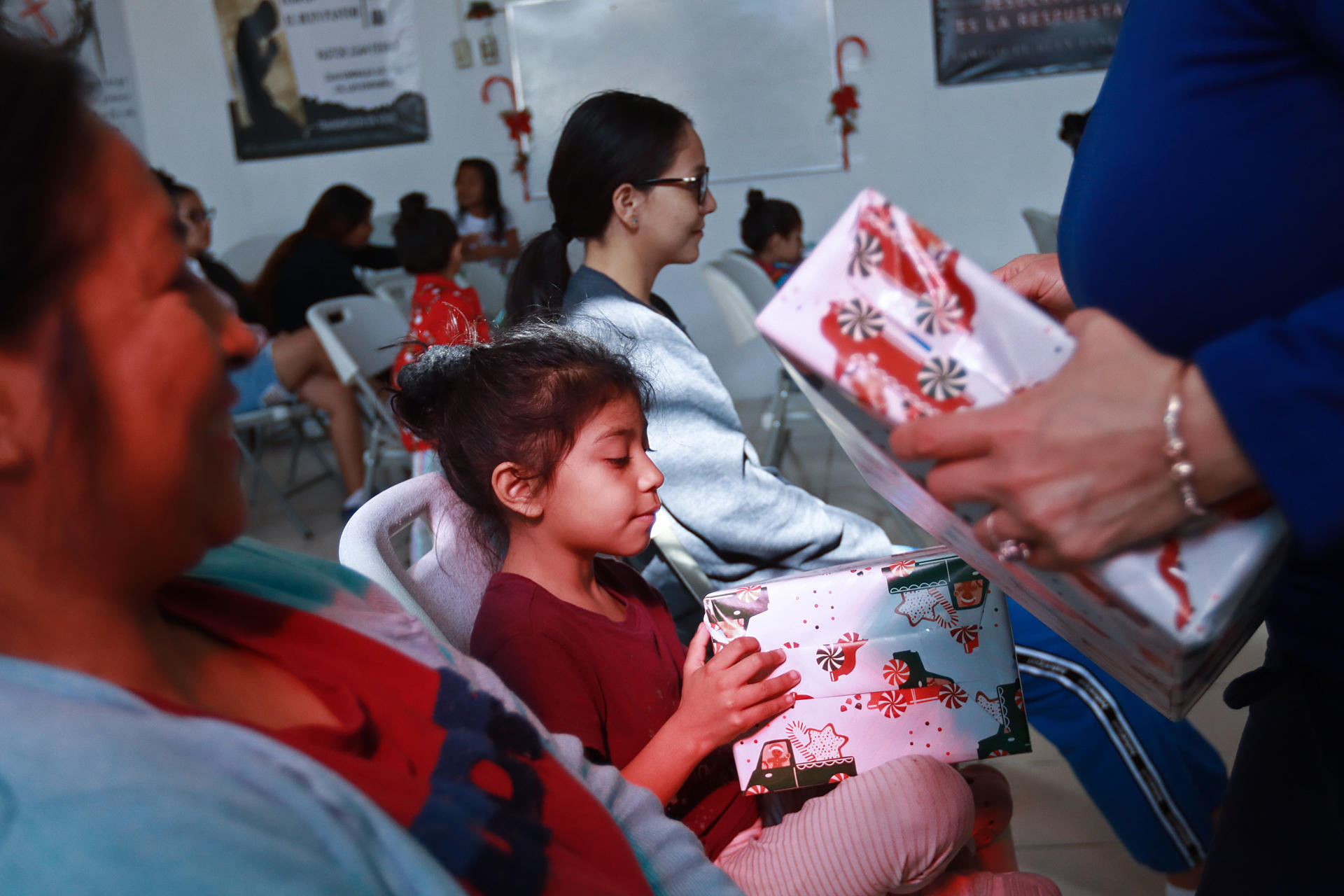 Migrantes que pasan la Navidad en el albergue 'El buen samaritano' reciben regalos, el 24 de diciembre de 2023, en Ciudad Juárez Chihuahua (México). EFE/ Luis Torres
