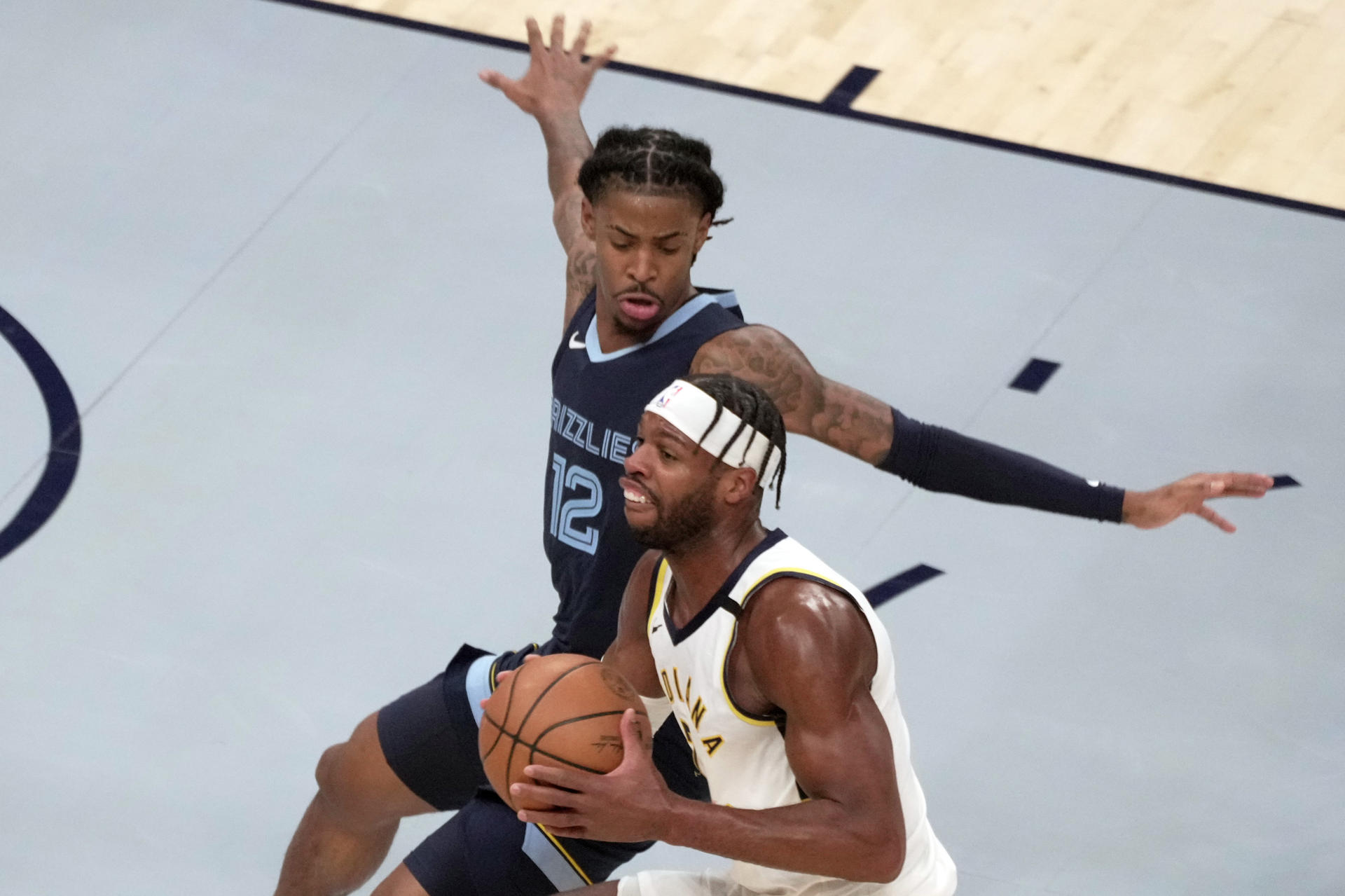 Ja Morant (arriba) de Memphis Grizzlies disputa un balón con Buddy Hield de Indiana Pacers en la primera parte de un partido en el FedEx Forum de Memphis, Tennessee (EEUU). EFE/ Karen Pulfer Focht
