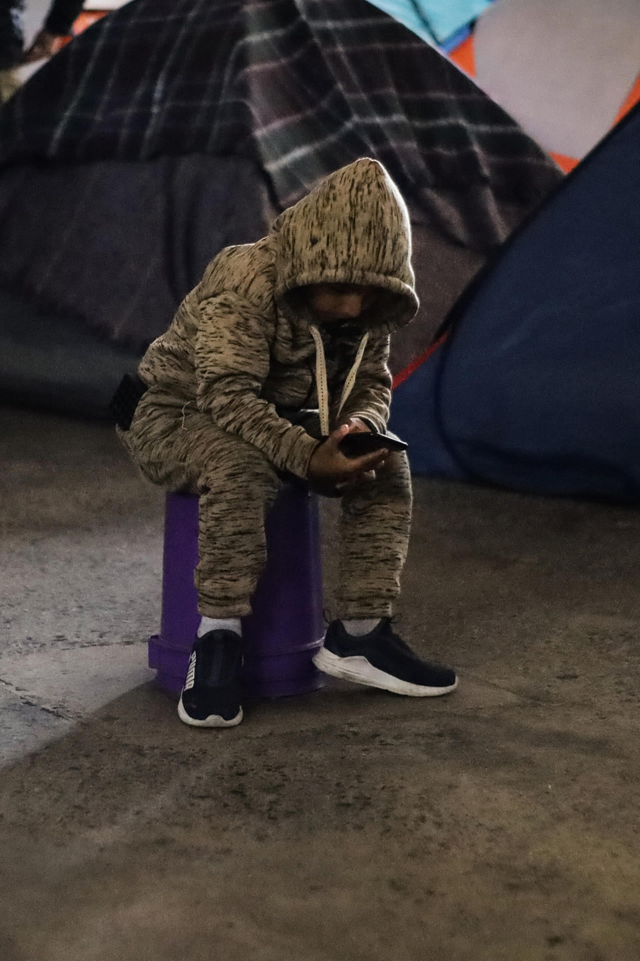 Un migrante observa su teléfono en el albergue Juventud 2000, el 16 de diciembre de 2023, en la ciudad de Tijuana en Baja California (México). EFE/ Joebeth Terriquez
