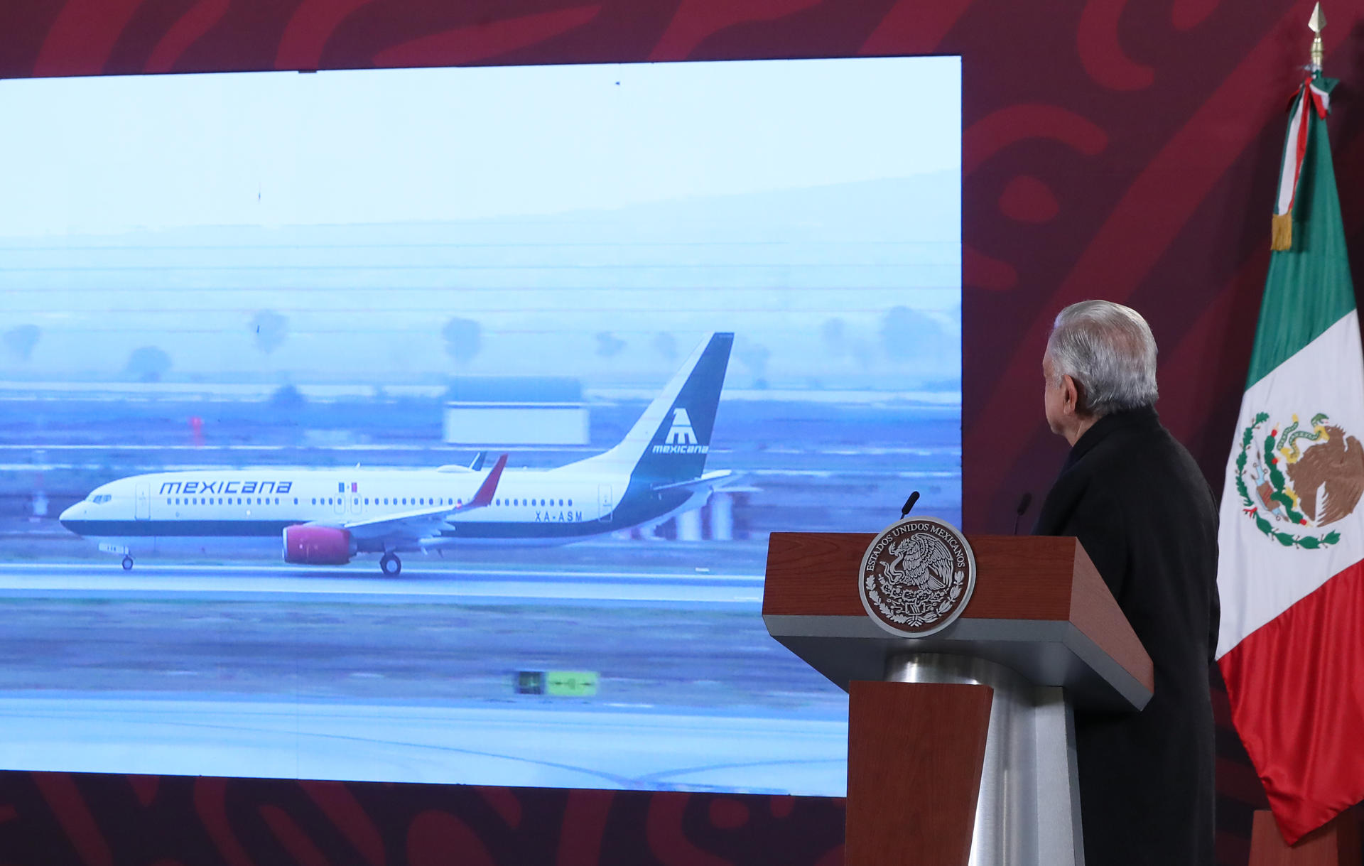 El presidente de México, Andrés Manuel López Obrador, observa la transmisión del despegue de un avión de la aerolínea Mexicana de Aviación en el aeropuerto internacional Felipe Ángeles, hoy, durante su rueda de prensa diaria en el Palacio Nacional de la Ciudad de México (México). EFE/ Mario Guzmán
