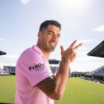 Fotografía cedida hoy por el Inter Miami CF donde aparece el atacante uruguayo Luis Suárez mientras sonríe visitiendo su camiseta número 9 del club de Miami frente al estadio DRV ONK en Fort Lauderdale, Florida (EEUU). EFE/Inter Miami CF