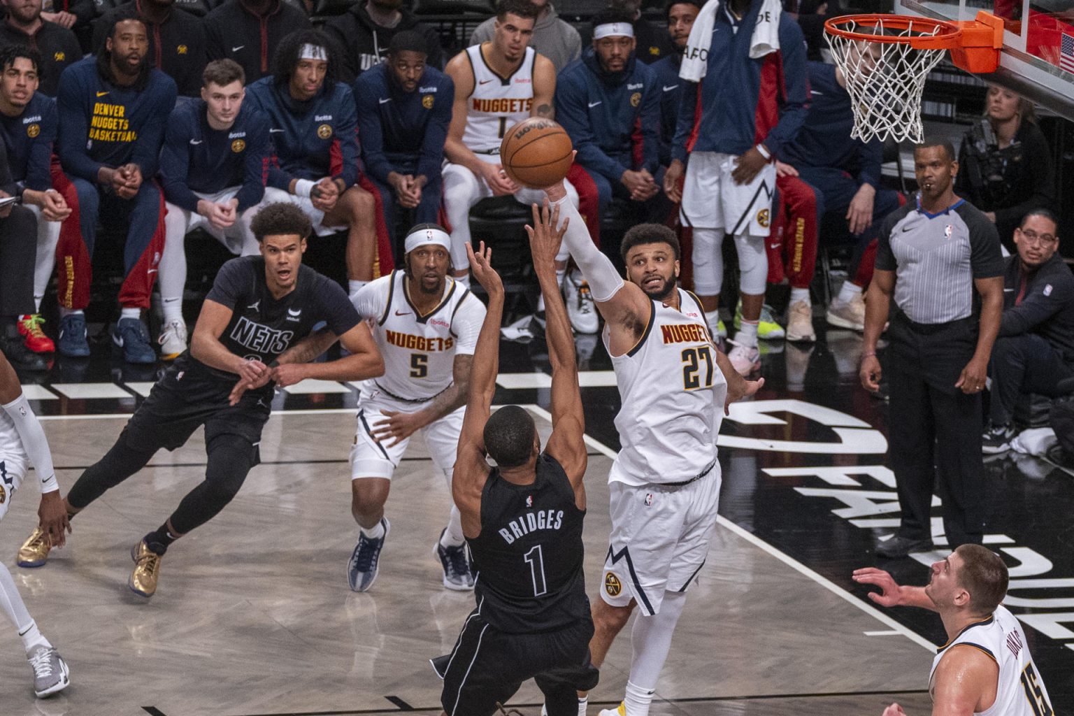 Jamal Murray (c-d), base canadiense de los Nuggets de Denver, fue registrado este viernes, 22 de diciembre, al bloquarle un disparo a Mikal Bridges (c), de los Nets de Brooklyn, durante un partido de la NBA, en el pabellón deportivo multiusos Barclays Center, en Brooklyn (Nueva York. EE.UU.). EFE/Ángel Colmenares