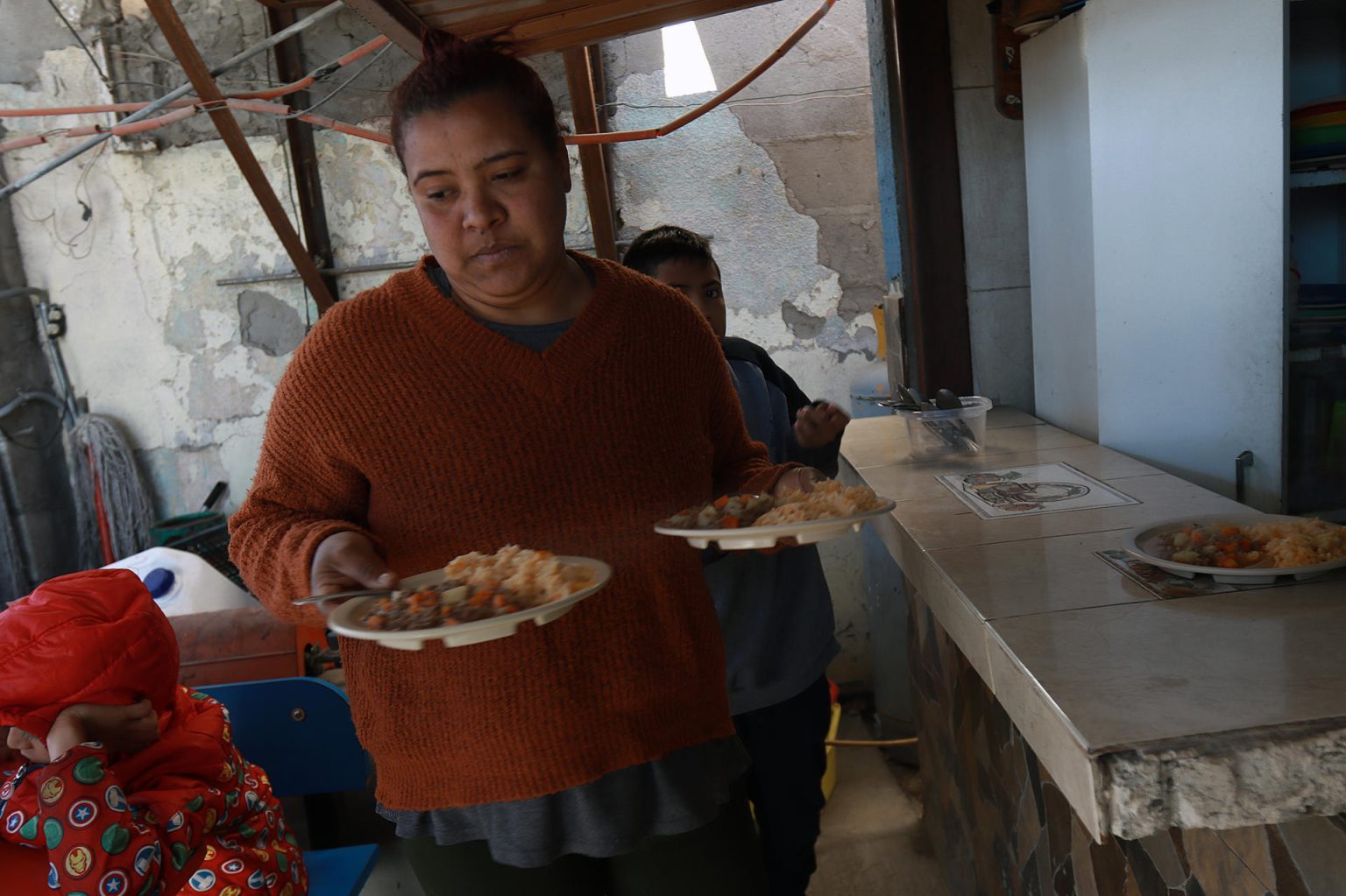 Una migrante sirve alimentos en el albergue 'Somos uno por Juárez', el 7 de enero de 2024, en Ciudad Juárez, Chihuahua (México). EFE/ Luis Torres