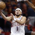 El guardia de los Phoenix Suns, Devin Booker (izq.), dispara alrededor del centro del Miami Heat, Bam Adebayo (der.) hoy, durante la primera mitad del partido de baloncesto de la NBA entre los Miami Heat y los Phoenix Suns en el Kaseya Center de Miami, Florida (EE. UU). EFE/ Rhona Wise