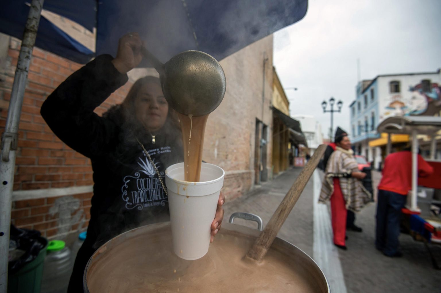 Una comerciante ambulante vende atole (dulce de maíz en agua) debido al descenso de la temperatura en la ciudad de Saltillo, estado de Coahuila (México). Imagen de archivo. EFE/Miguel Sierra.