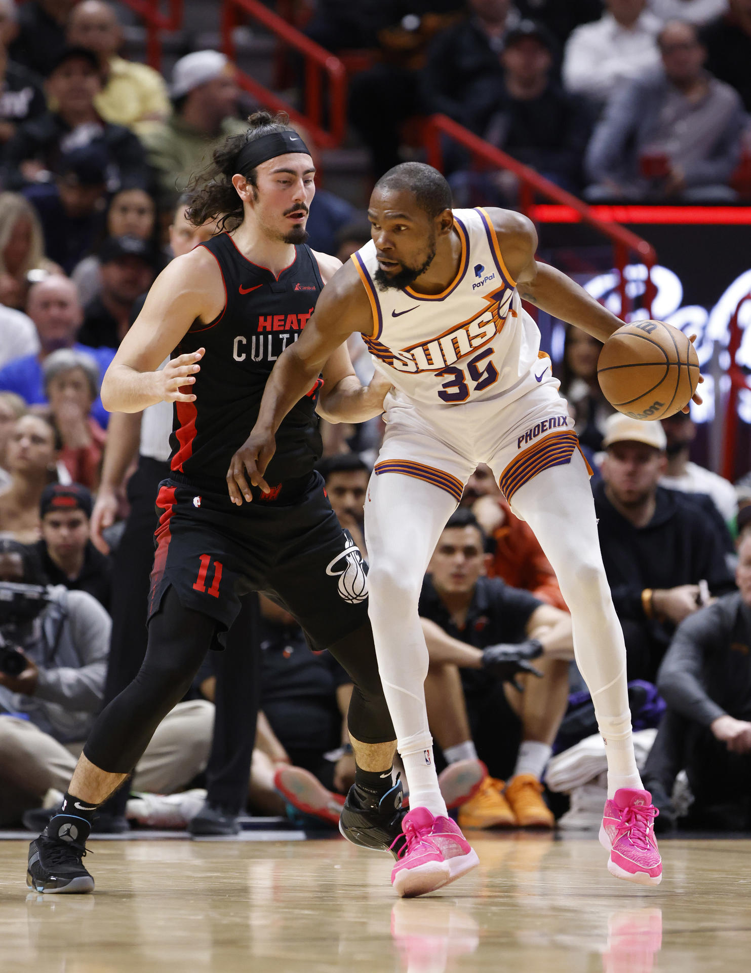 El delantero de los Phoenix Suns, Kevin Durant (der.) pasa el balón más allá del guardia del Miami Heat, Jaime Jaquez Jr. (izq.) hoy, durante la primera mitad del partido de baloncesto de la NBA entre los Miami Heat y los Phoenix Suns en el Kaseya Center de Miami, Florida (EE. UU). EFE/ Rhona Wise
