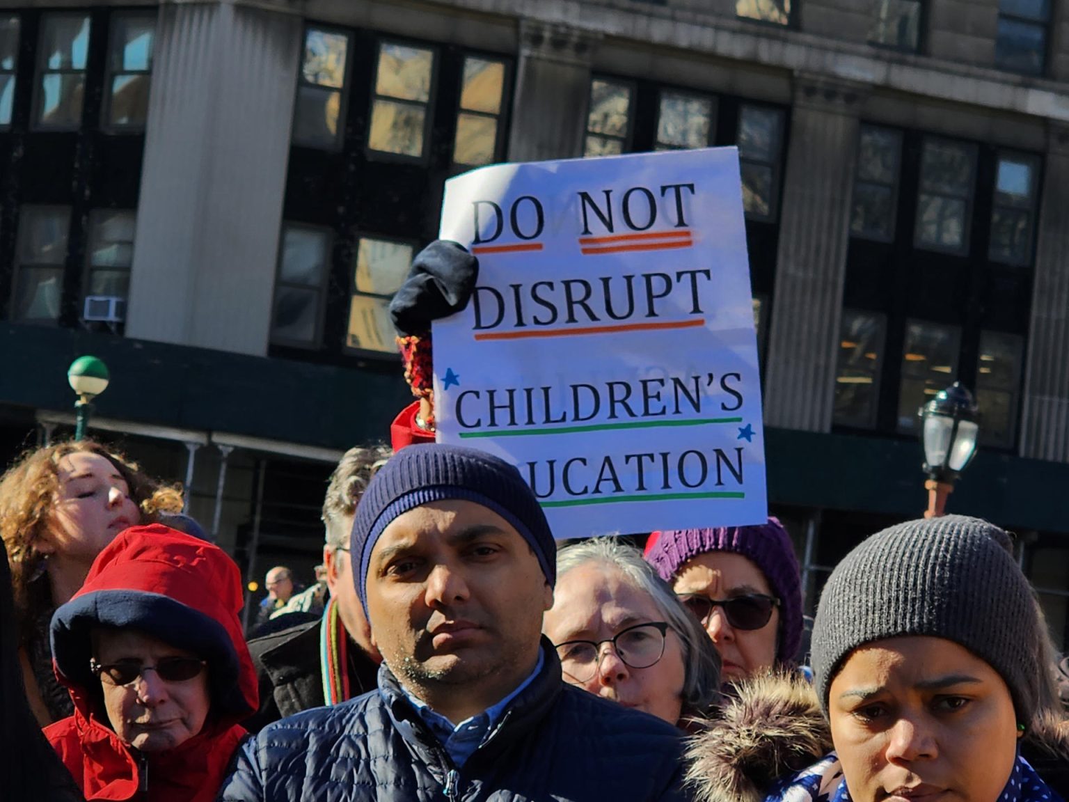 Una persona sostiene una pancarta que pide al alcalde no interrumpir la educación de los niños con el desalojo de las familias inmigrantes durante una manifestación en apoyo a los inmigrantes llegados a la ciudad hace un año celebrada hoy a pocos pasos de la alcaldía de Nueva York (Estados Unidos). EFE/Ruth E. Hernández