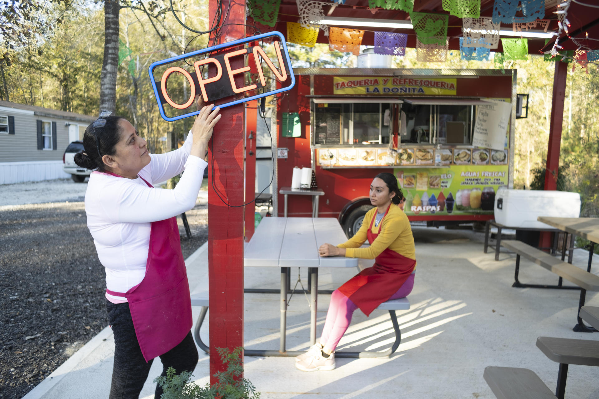 Yelva Cortés (i) y Yolanda Romero (d), ambas naturales de Michoacán (México), esperan clientes en el restaurante móvil donde trabajan en el condado Liberty, el 30 de diciembre de 2023, al noreste de Houston, Texas (Estados Unidos). EFE/ Alicia L. Pérez
